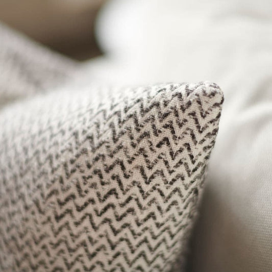 The Audrey Zig Zag Reversible Cotton Cushion is dynamic in design and texture, with a reversible pattern weave that elicits the senses and brings life to any space. It is crafted of 100% cotton chenille, featuring a Japanese-style flange and an exclusive plump feather insert for superior comfort. Corner close up.