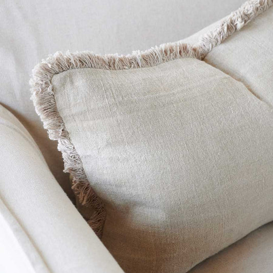 The Avery Linen Fringed Neutral Cushion is crafted with 100% European Linen and adorned with a delicate cotton fringe. Its plump feather insert offers unbeatable comfort, making it the top choice on the market. Corner close up.