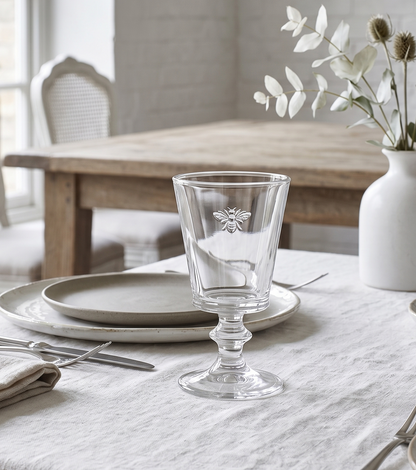 Dining table setting with a bee wine & water glass