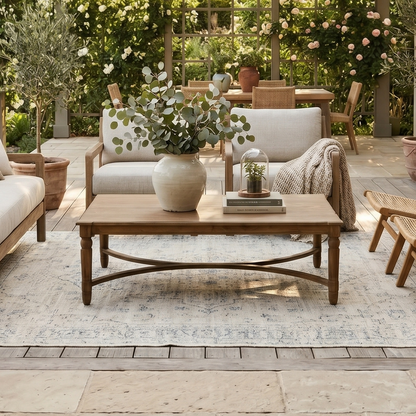Outdoor patio with wooden furniture, potted plants, and a floral archway.
