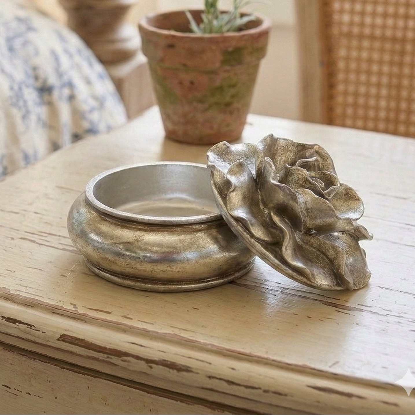 Decorative items on a wooden table with a bed and chair in the background