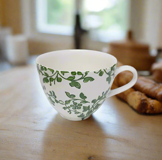 This organically shaped mug is ideal for enjoying a generous serving of coffee, tea, or hot chocolate. Adorned with a hand-painted green Florentine leaf design on a creamy ivory glaze, it adds a fresh and vibrant touch to any kitchen.