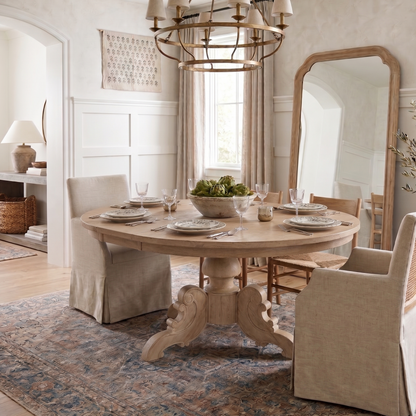 Dining room with wooden table and chairs, chandelier, and large mirror.
