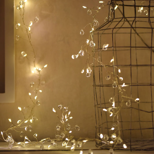 This set of decorative Crystal Cluster Fairy String Lights will add a touch of sophistication to any tabletop or mantel with its 200 warm LED lights and shimmering clear crystals. 