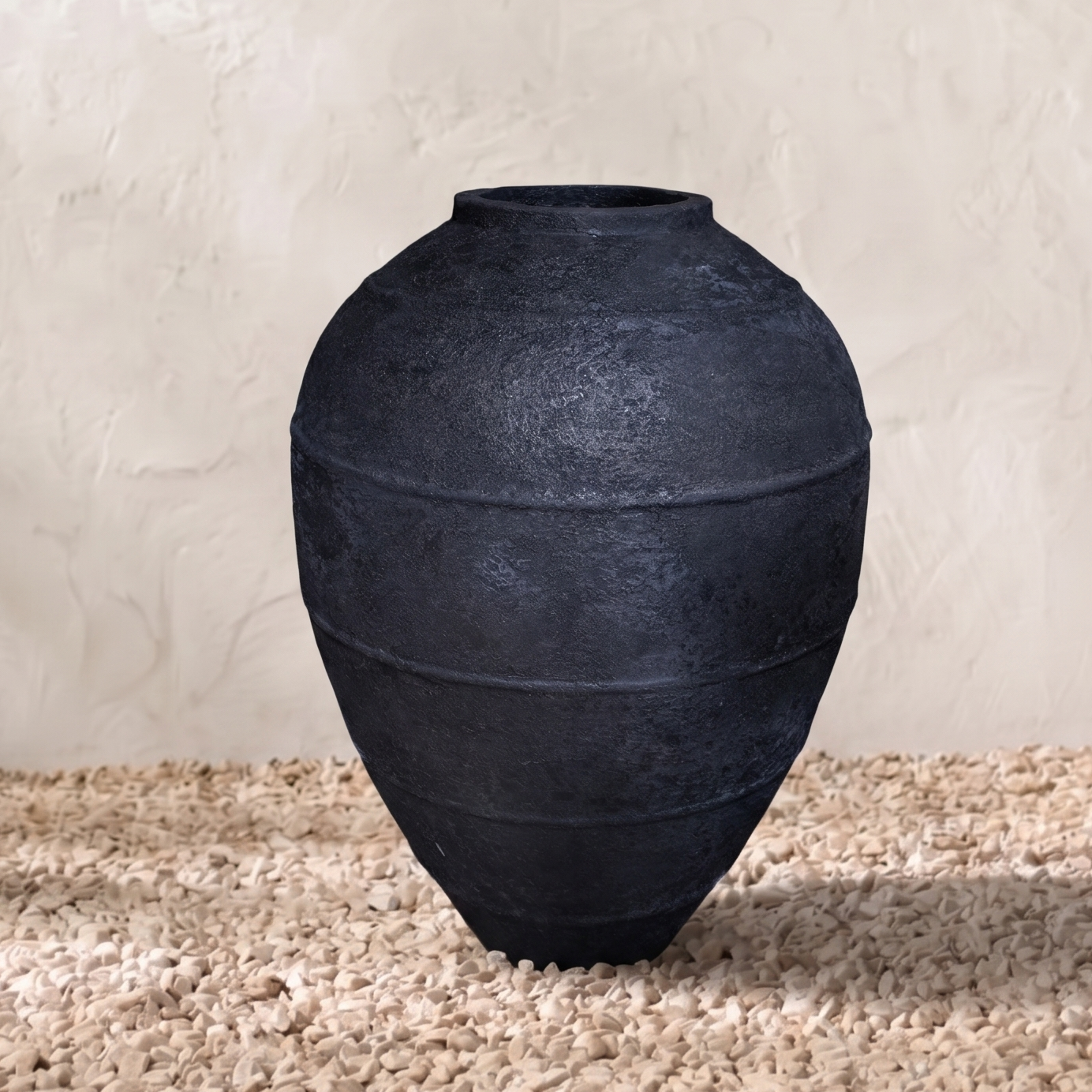 Black pot on a textured surface with a neutral background