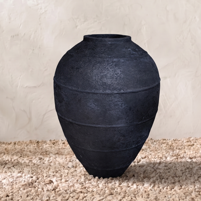 Black pot on a textured surface with a neutral background
