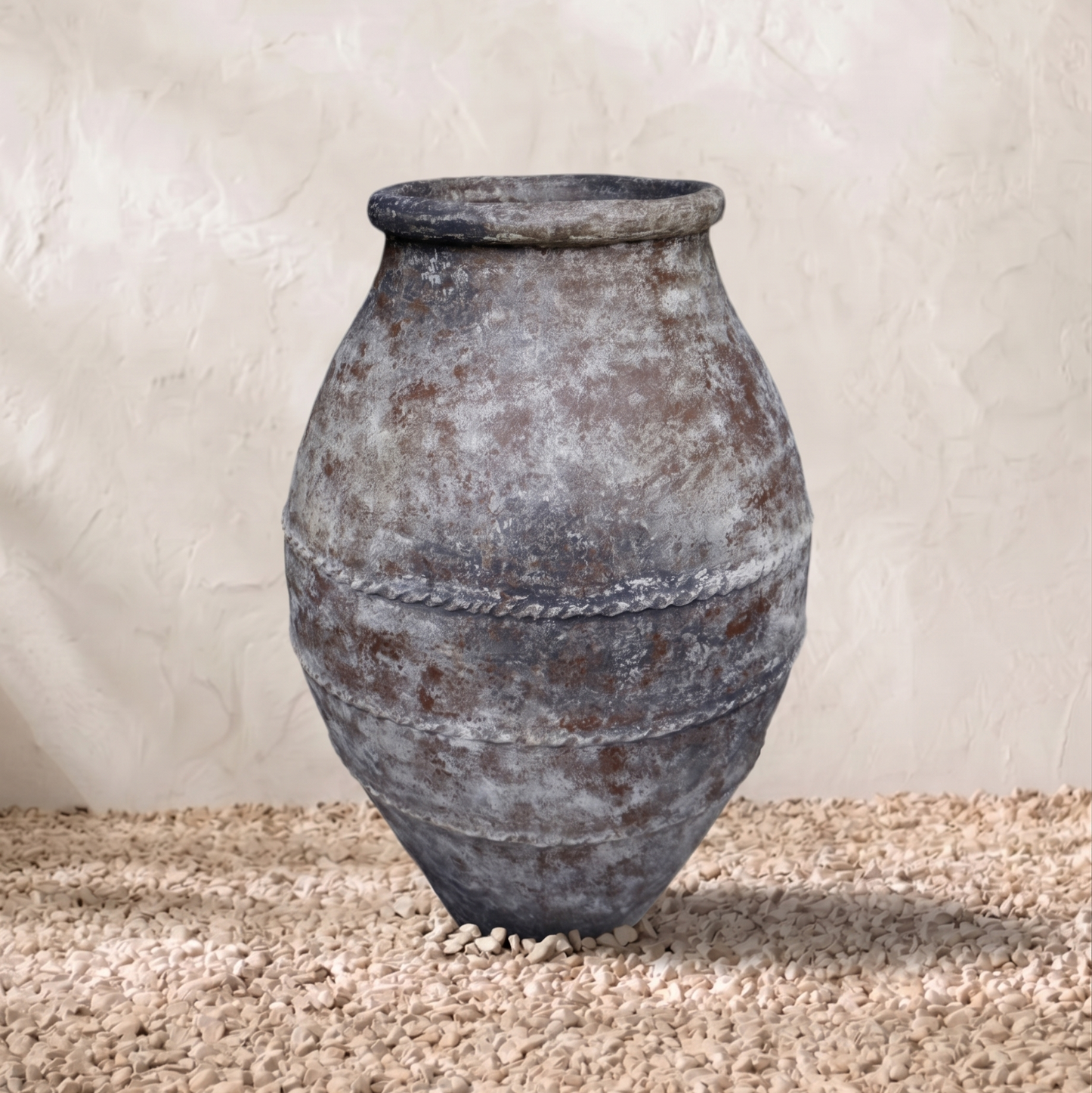 Vintage-style terracotta pot on a textured surface with a neutral background