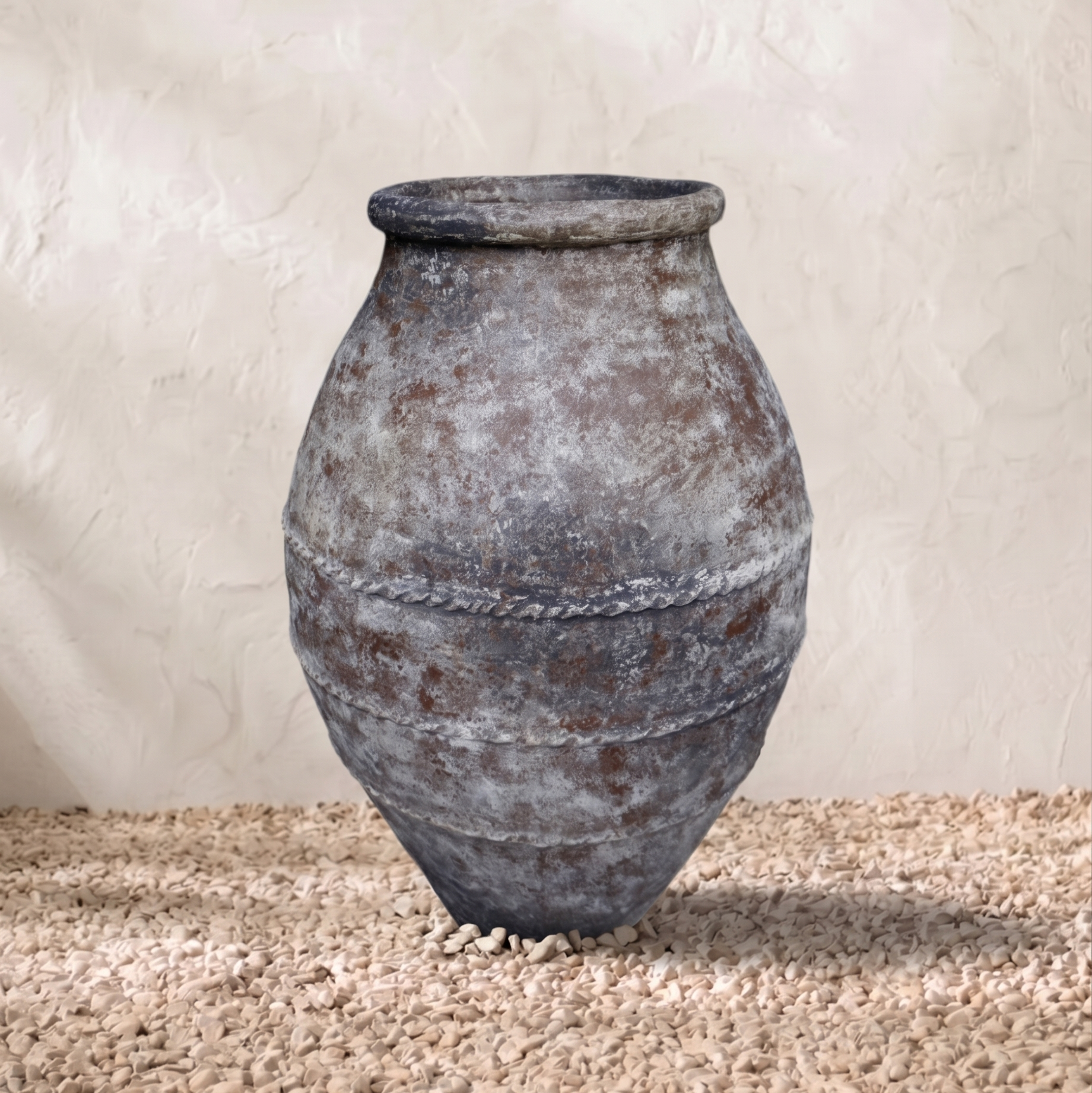 Vintage-style terracotta pot on a textured surface with a neutral background
