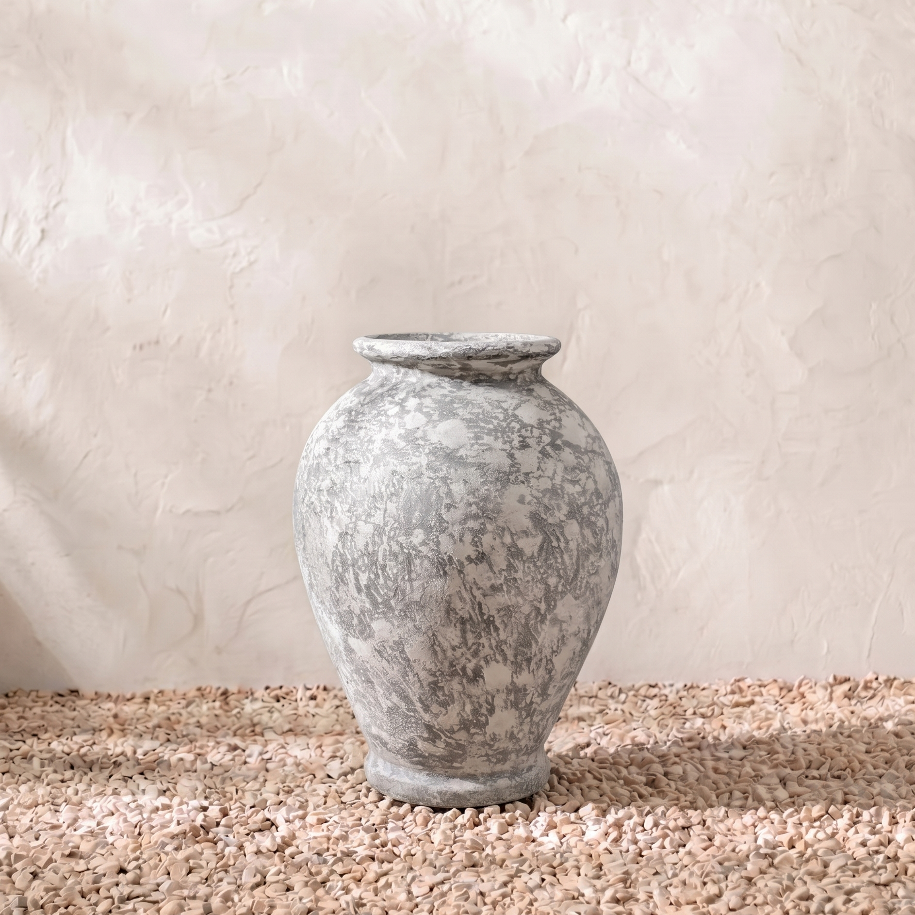 Decorative stone urn on a textured surface with a neutral background