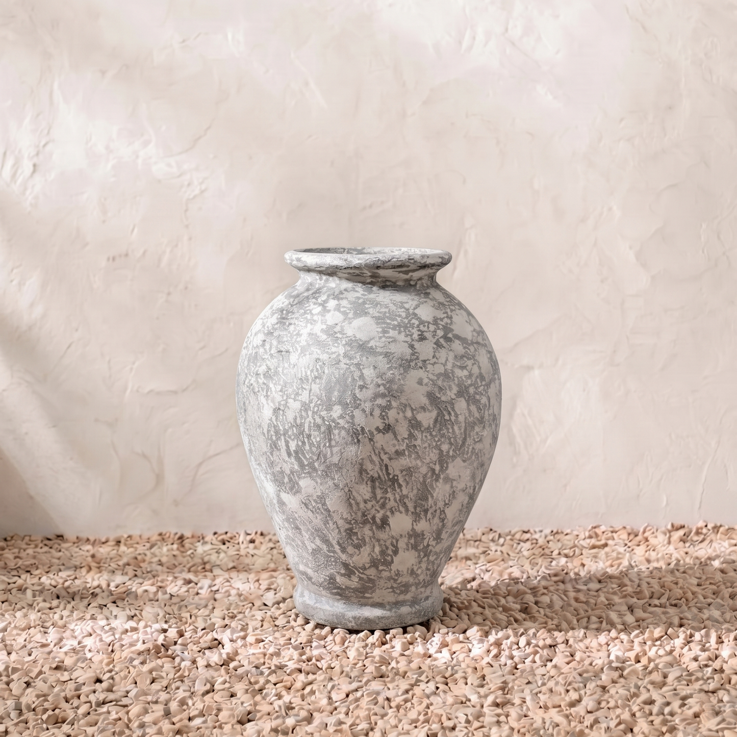 Decorative stone urn on a textured surface with a neutral background