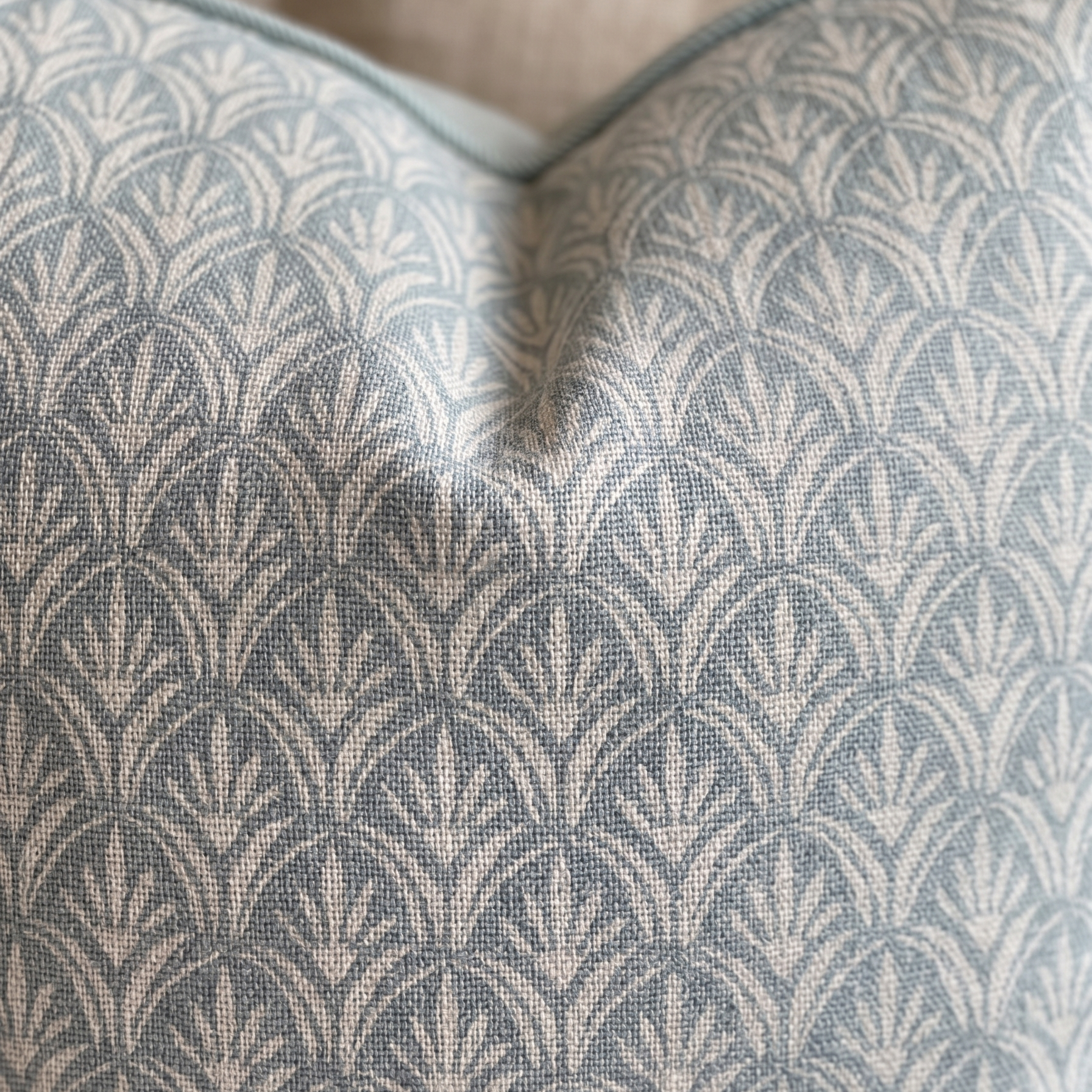 Close-up of a textured fabric with a geometric pattern on a pillow.