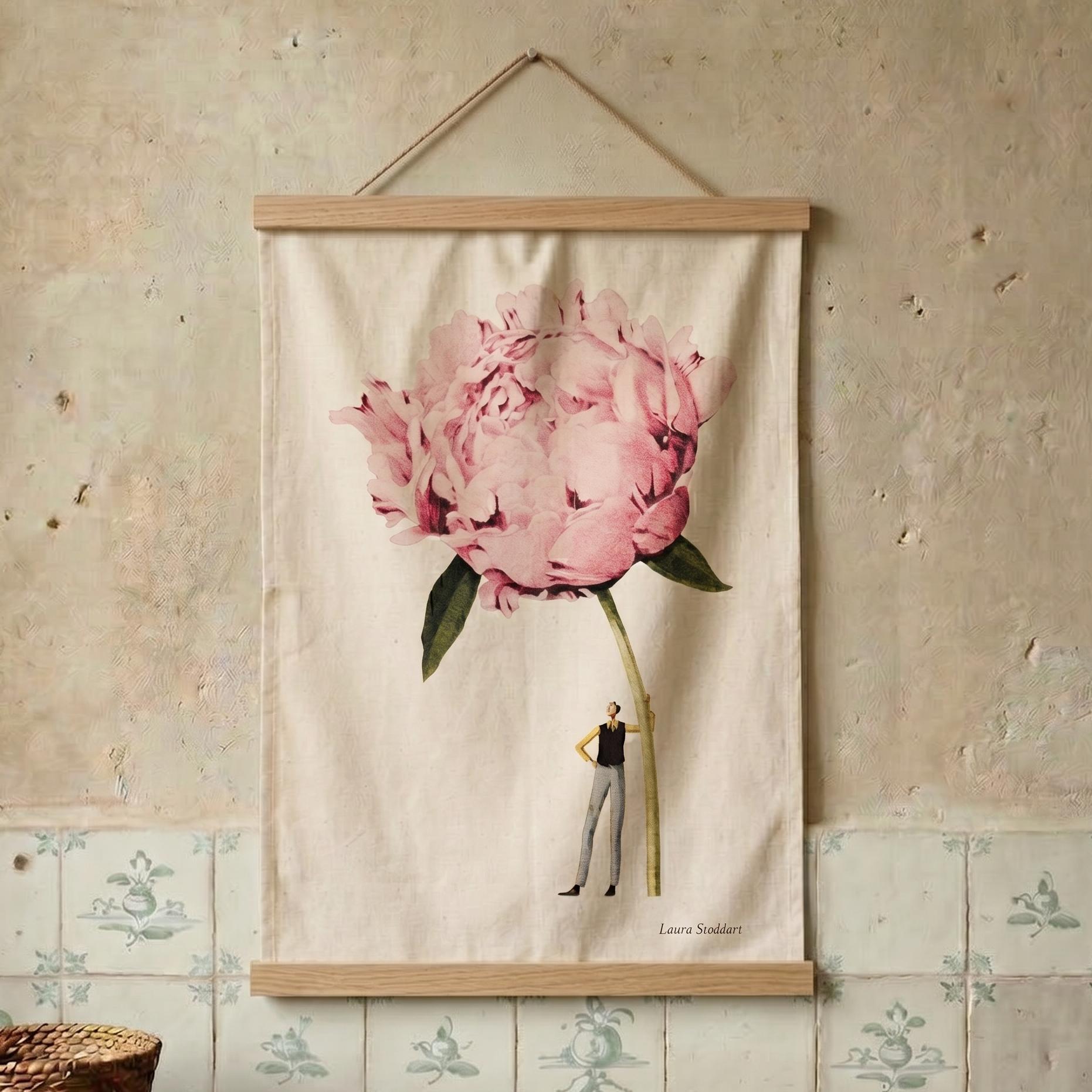 Floral tea towel with a person inside a pink flower hanging on a textured wall.