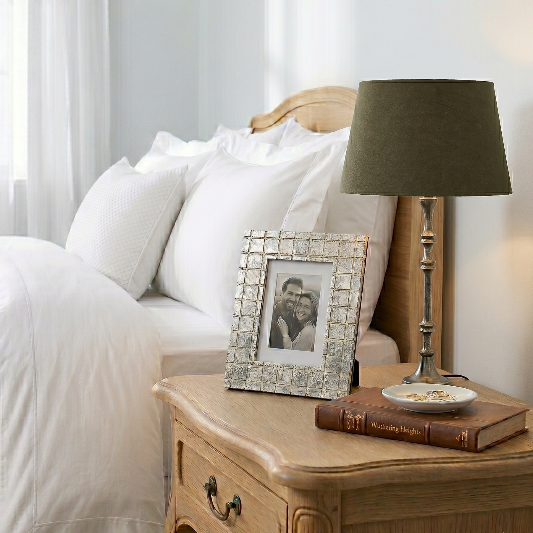 Bedroom with wooden nightstand, lamp, and photo frame.
