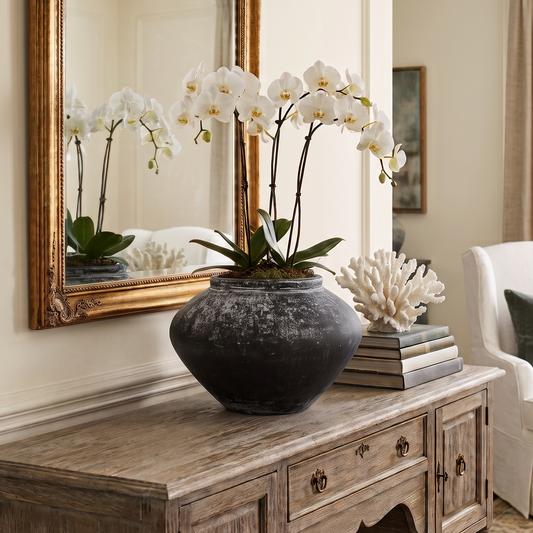 Living room with wooden console table, vase with flowers, and armchair.
