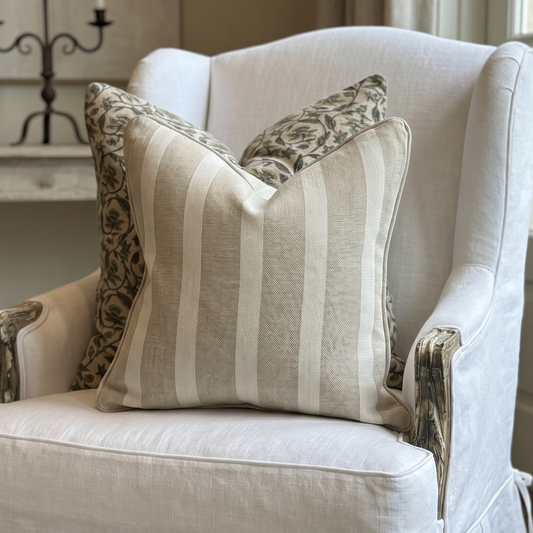 White armchair with patterned pillows in a room setting