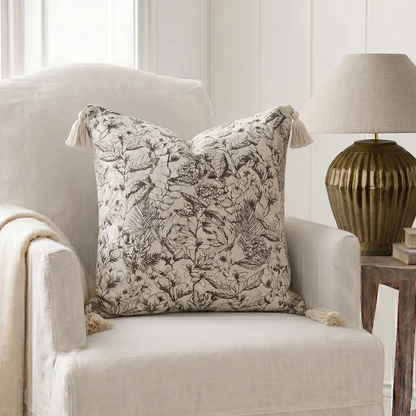 Decorative pillow on a chair with a lamp and books in the background