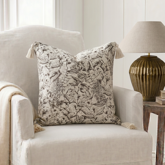 Decorative pillow on a chair with a lamp and books in the background