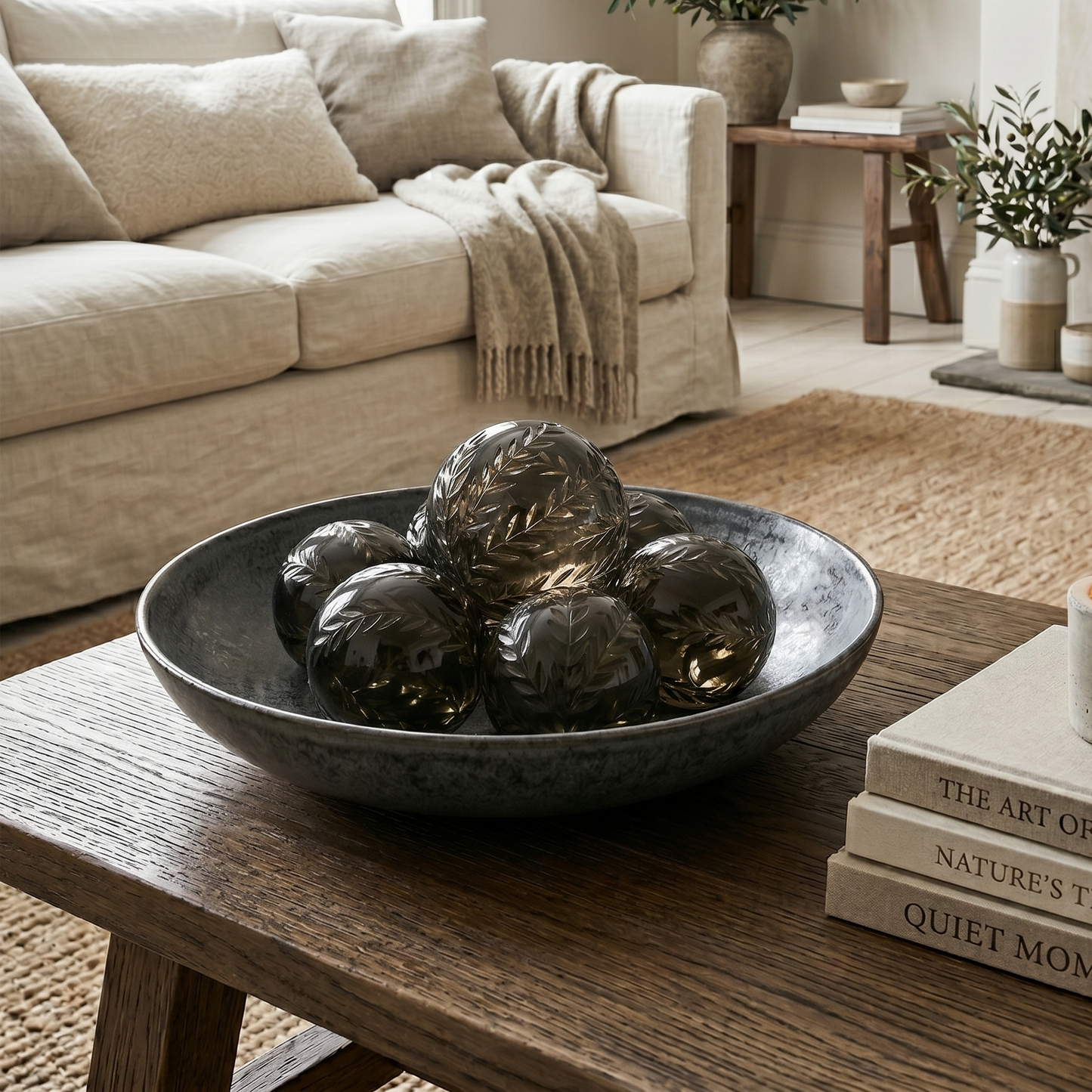 Living room with a beige sofa, decorative bowl, and books on a wooden table.
