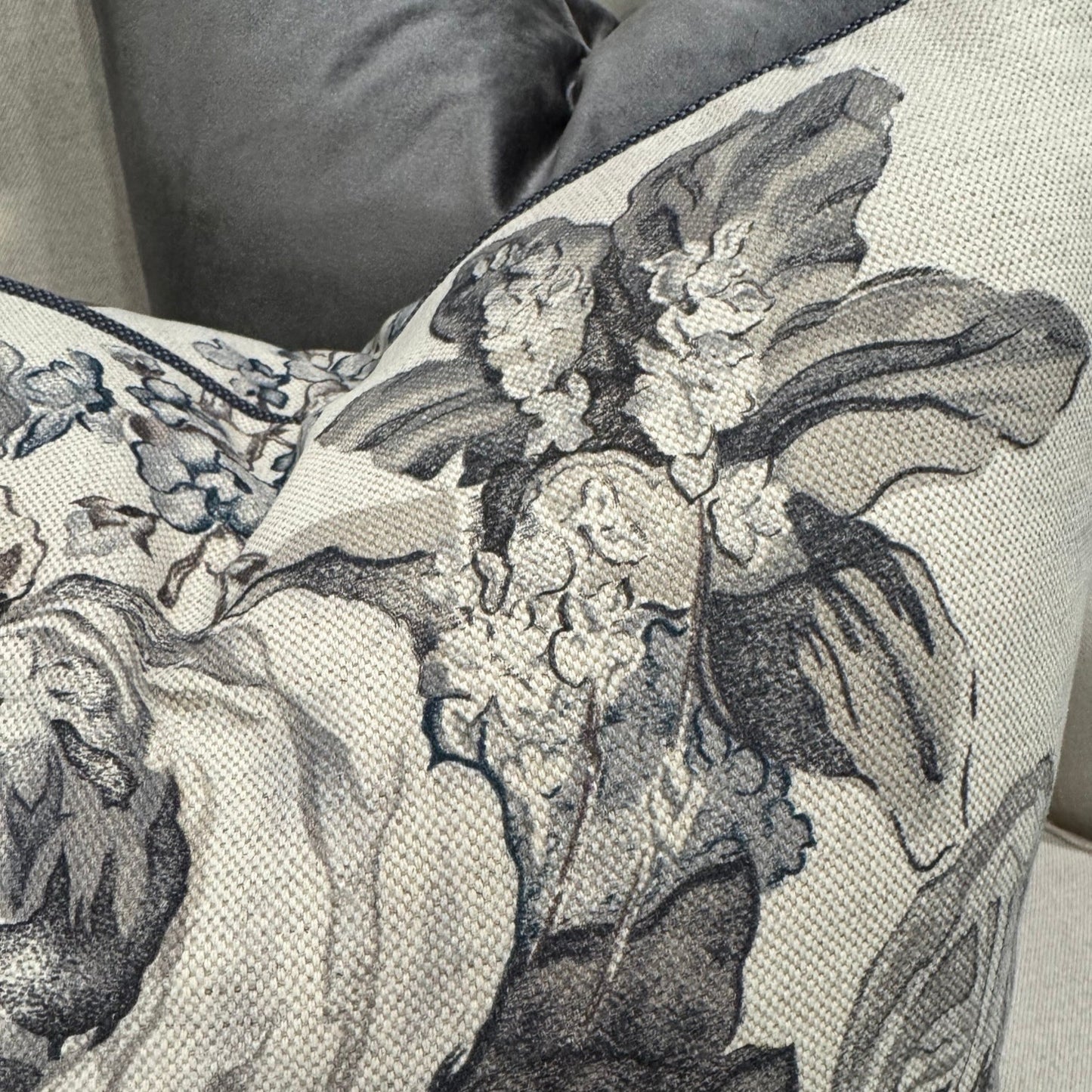 Revitalize your interior with the Warwick Grey Floral Linen &amp; Cotton Cushion, crafted from premium fabric by the distinguished Warwick Fabrics. The exquisite floral pattern in sophisticated grey and taupe tones creates a striking contrast against its neutral base, commanding attention in any room. This sumptuous cushion effortlessly enhances sofas, chairs, or bedding while delivering exceptional comfort with its lavish feather filling. An irresistible statement piece that elevates your home's ambiance