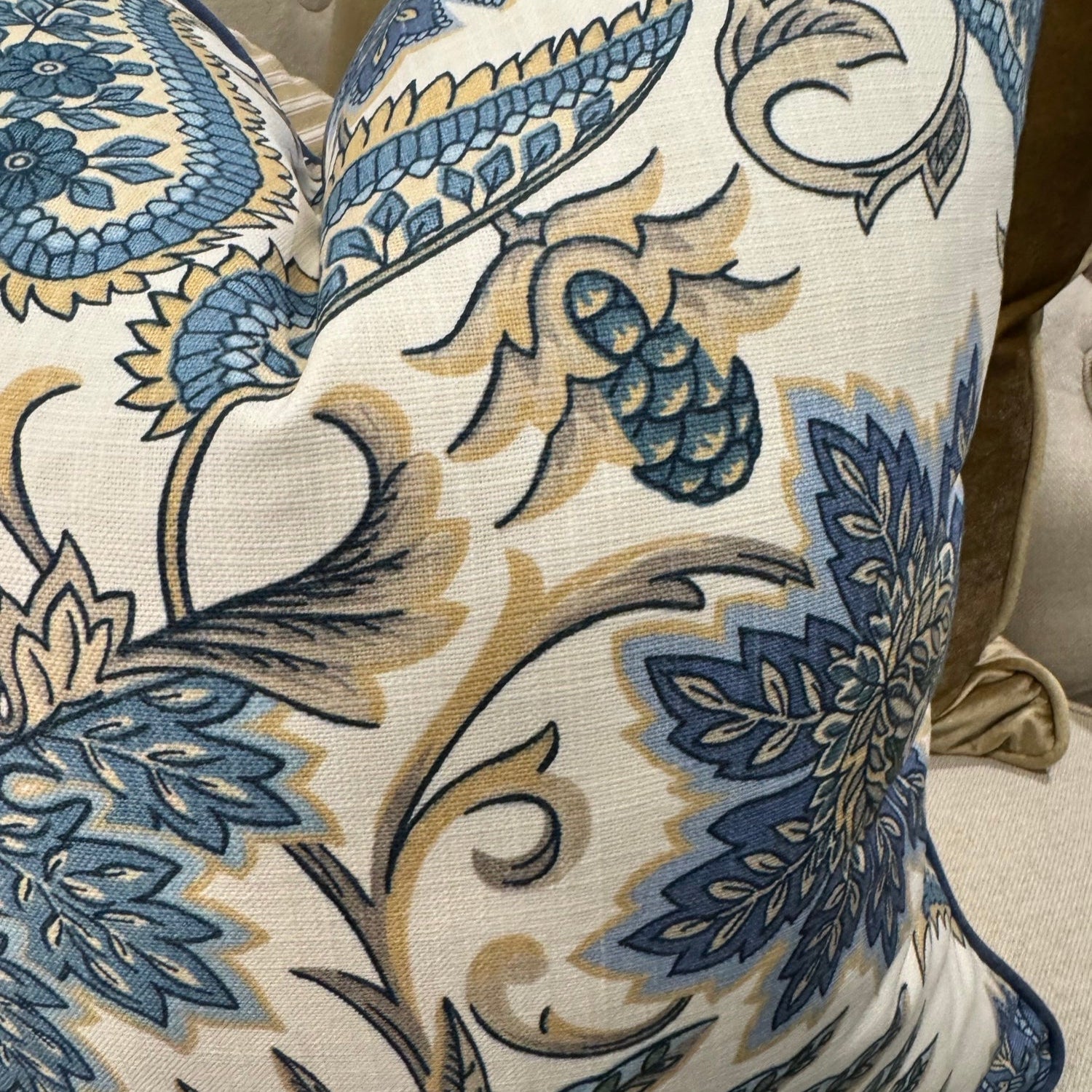 Elevate your interior with the Emily Blue &amp; Taupe Floral Cushion, masterfully crafted using superior fabrics. The sophisticated floral pattern displays captivating blue and taupe hues on a pristine ivory canvas, drawing admiring glances in any setting. Flip to reveal a refined ochre ticking stripe complemented by rich deep blue piping for versatile styling options. 