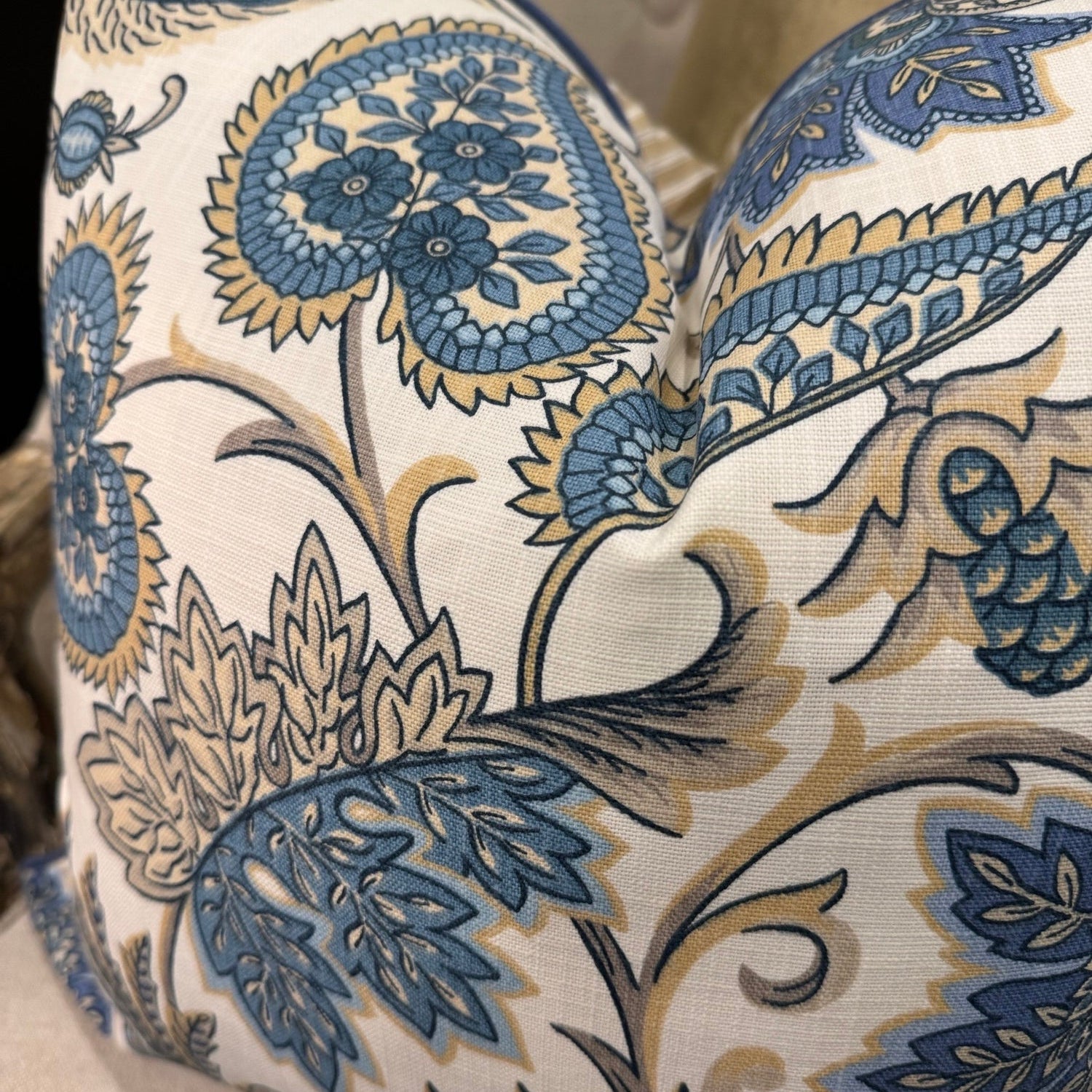 Elevate your interior with the Emily Blue &amp; Taupe Floral Cushion, masterfully crafted using superior fabrics. The sophisticated floral pattern displays captivating blue and taupe hues on a pristine ivory canvas, drawing admiring glances in any setting. Flip to reveal a refined ochre ticking stripe complemented by rich deep blue piping for versatile styling options. 