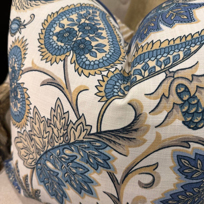 Elevate your interior with the Emily Blue &amp; Taupe Floral Cushion, masterfully crafted using superior fabrics. The sophisticated floral pattern displays captivating blue and taupe hues on a pristine ivory canvas, drawing admiring glances in any setting. Flip to reveal a refined ochre ticking stripe complemented by rich deep blue piping for versatile styling options. 