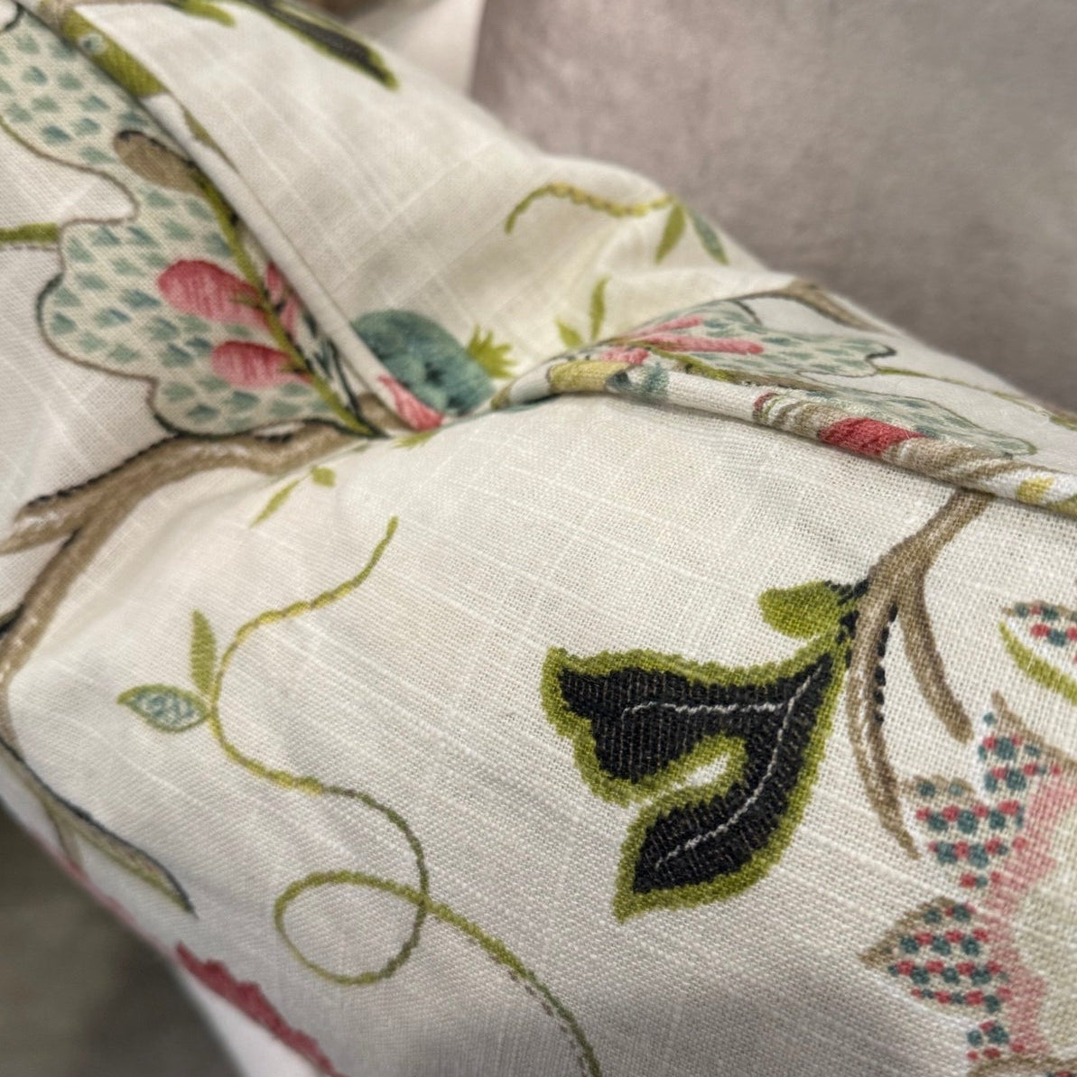 Transform your home decor this season with the elegant Colette Pink &amp; Green Floral Lumbar Cushion. Revel in the stunning pink and green flowers against a neutral backdrop, making it an ideal statement piece for any space. With a plush insert filled with feathers, you can enjoy both luxury and flair. The other side highlights a neutral tone, adding versatility.