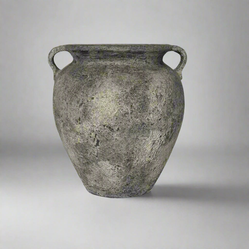 Ancient terracotta jar with two handles on a gray background