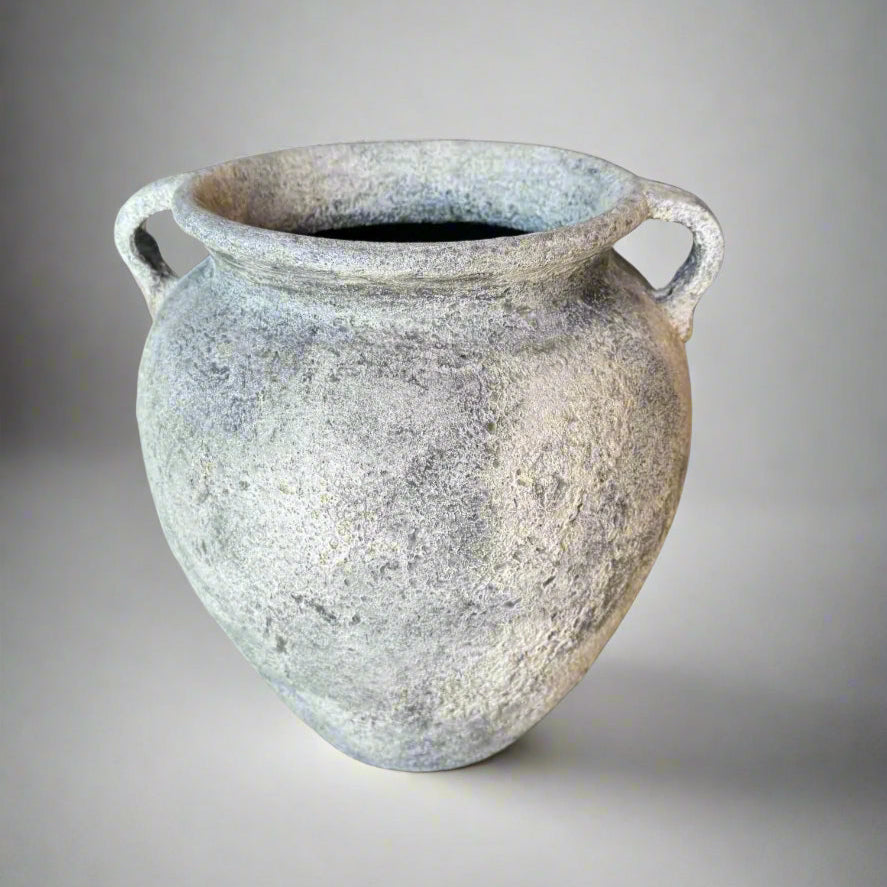 Vintage-style ceramic vase with textured surface on a gray background