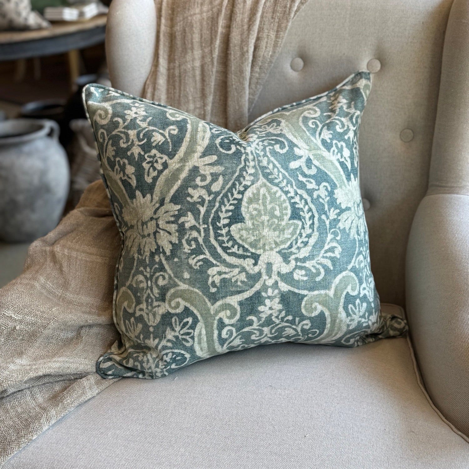 Decorative pillow with paisley pattern on a beige sofa