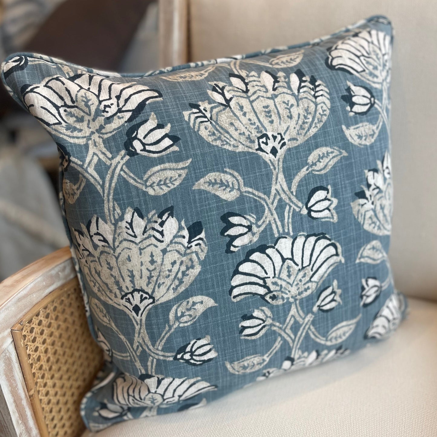 The heavyweight Pradesh Art Deco Floral Blue Taupe Cushion, featuring a refined pattern from Robert Allen Fabrics, is sure to add a touch of sophistication to any room. Utilizing a composition of pale taupe, off white, and blue hues, its feather-filled insert provides unparalleled comfort for a truly cozy feel.