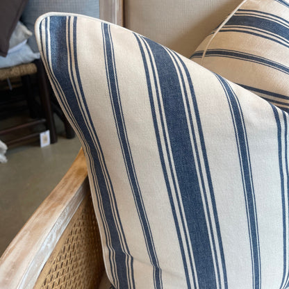 This classic heavyweight Coastal Blue Stripe Cushion, with a sophisticated pattern provided by international fabric house Laura & Kiran, makes any space feel elegant. Combining off white and blue tones, the cushion is complete with a luxuriously soft feather insert to create a truly cozy experience! Corner close up.