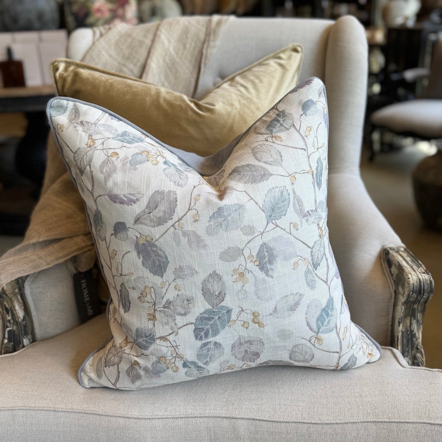 Decorative pillows on a gray armchair in a store setting