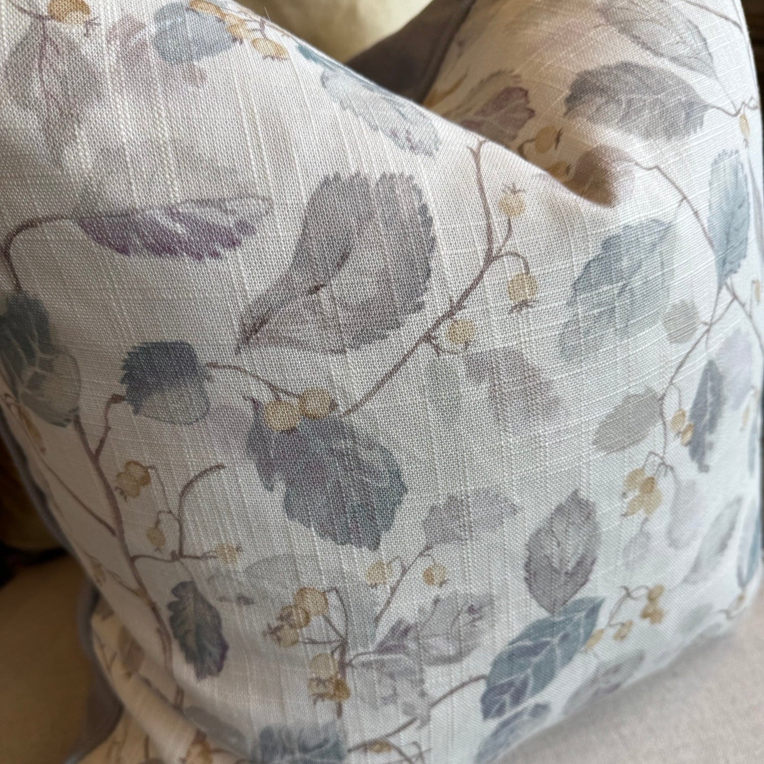 Floral-patterned pillow on a beige sofa