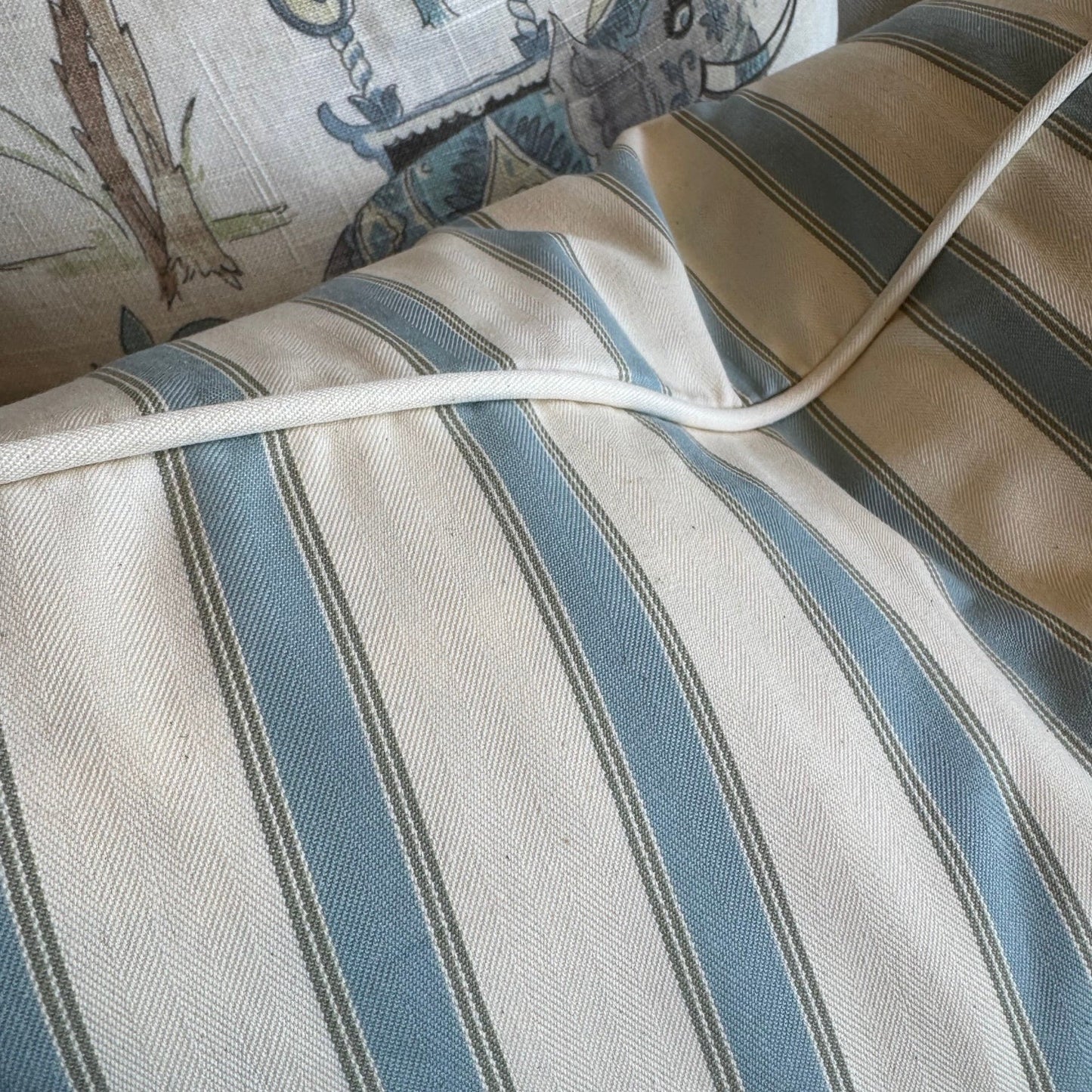 Close-up of a striped fabric with blue and gray lines on a textured surface.