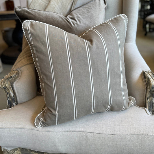 Decorative pillows on a ornate armchair in a home setting