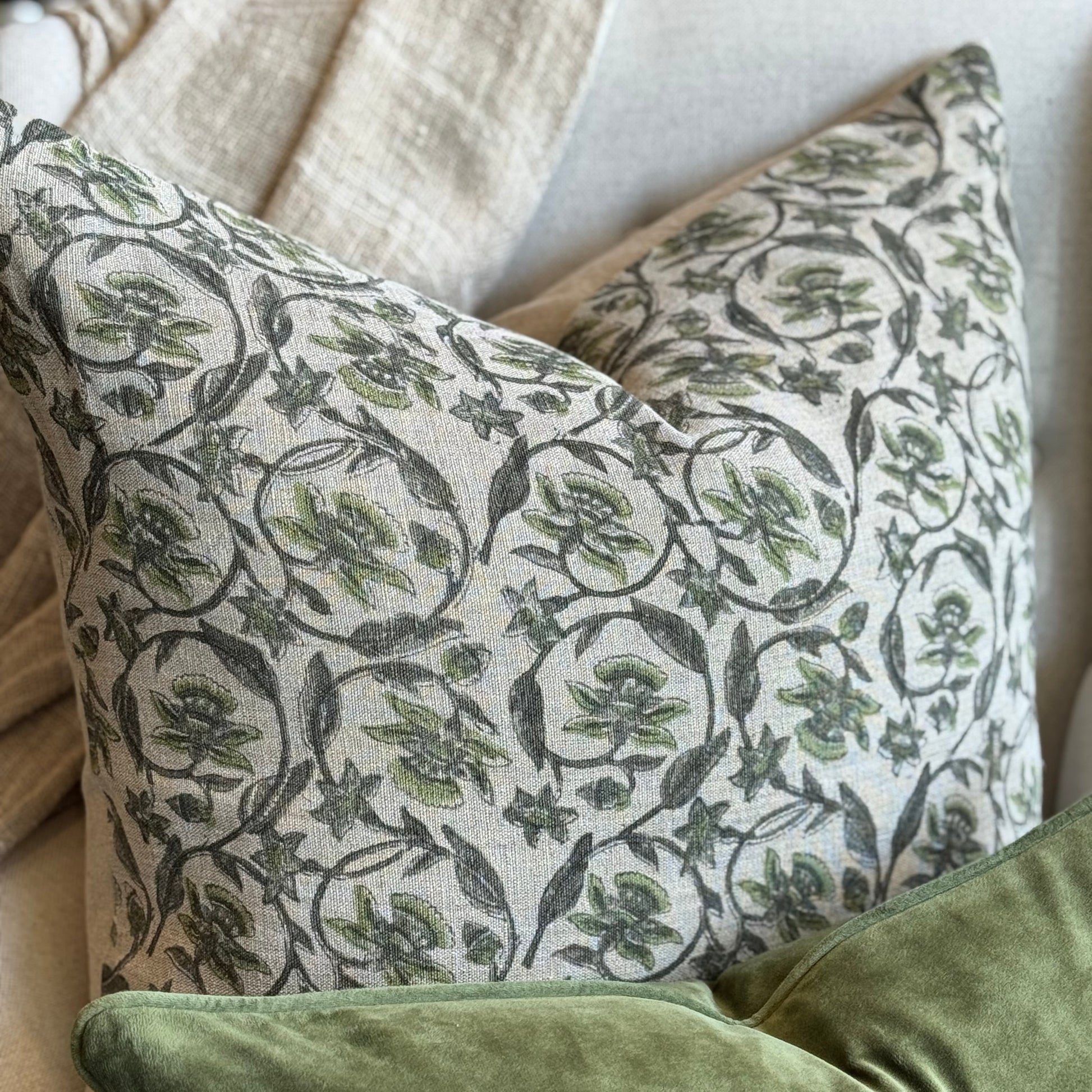 Patterned and solid green pillows on a sofa