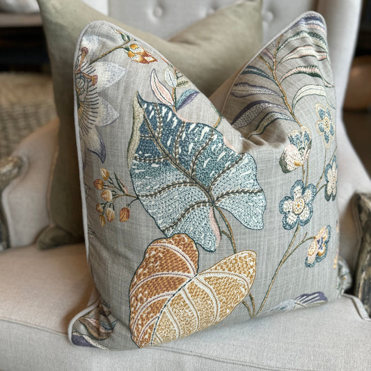 Indulge in the exquisite artistry of this luxurious Claudette Floral Linen Cushion. Crafted from a sturdy linen blend, it showcases a stunning floral pattern in vibrant hues against a subtle taupe background, with a reverse side of elegant neutral fabric. A feather insert adds an extra touch of comfort.