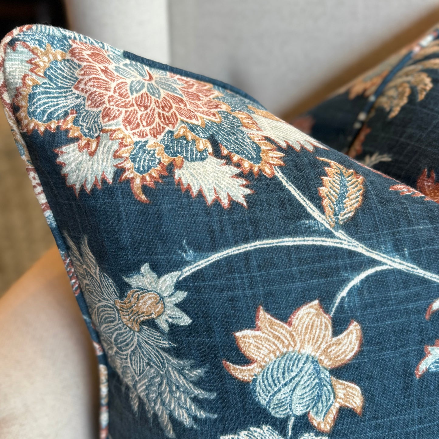 Experience the exquisite craftsmanship of this premium Lily Floral Navy Linen Cushion. Made with a heavy weight linen blend fabric, it features a gorgeous floral design in rich colours on a navy backdrop. Includes a feather insert for added comfort. Corner close up.