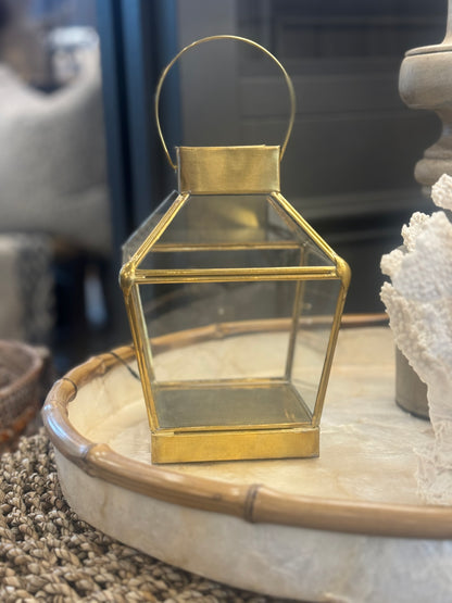 Transform any table or sideboard into a stunning display with our Handmade Mana Brass & Glass Lantern. Crafted from brass and glass, this lantern adds a touch of charm, just lift the delicate pin fixing to open the small glass door and insert a candle for a warm and inviting glow. Side.