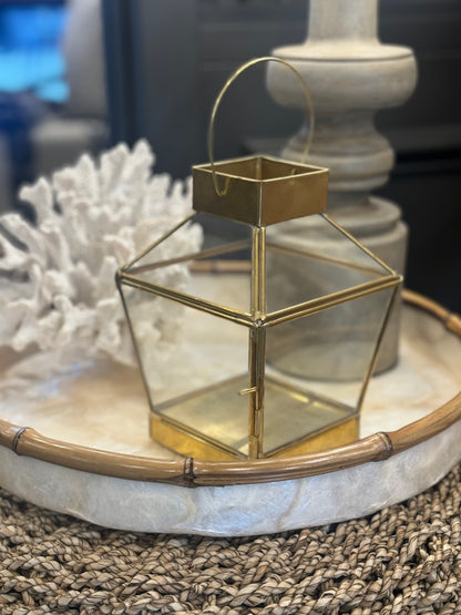 Transform any table or sideboard into a stunning display with our Handmade Mana Brass & Glass Lantern. Crafted from brass and glass, this lantern adds a touch of charm, just lift the delicate pin fixing to open the small glass door and insert a candle for a warm and inviting glow. Side.