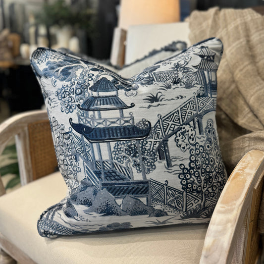 Experience comfort and luxury with the Asaka Toile Blue &amp; White Cushion, crafted with care from premium Covington fabric. Adorned with a stunning blue willow pattern on a crisp white backdrop, and filled with soft feathers for ultimate comfort.