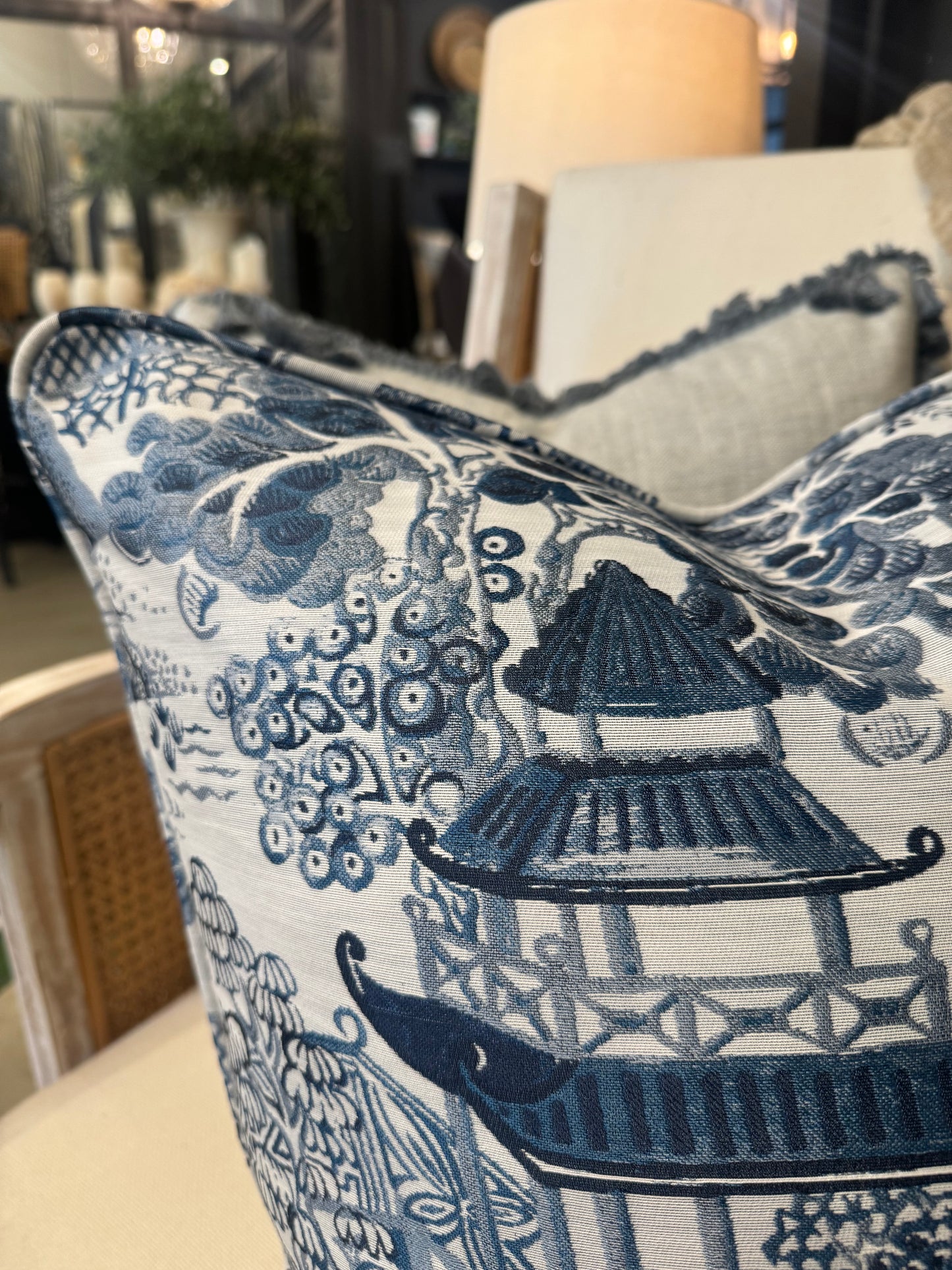 Experience comfort and luxury with the Asaka Toile Blue &amp; White Cushion, crafted with care from premium Covington fabric. Adorned with a stunning blue willow pattern on a crisp white backdrop, and filled with soft feathers for ultimate comfort. detail