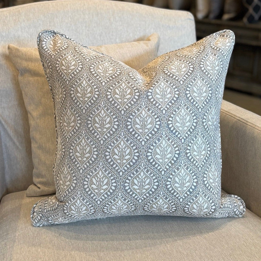 Decorative pillow on a beige armchair in a store setting