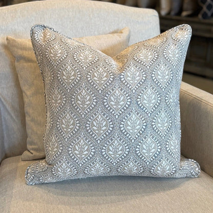 Decorative pillow on a beige armchair in a store setting