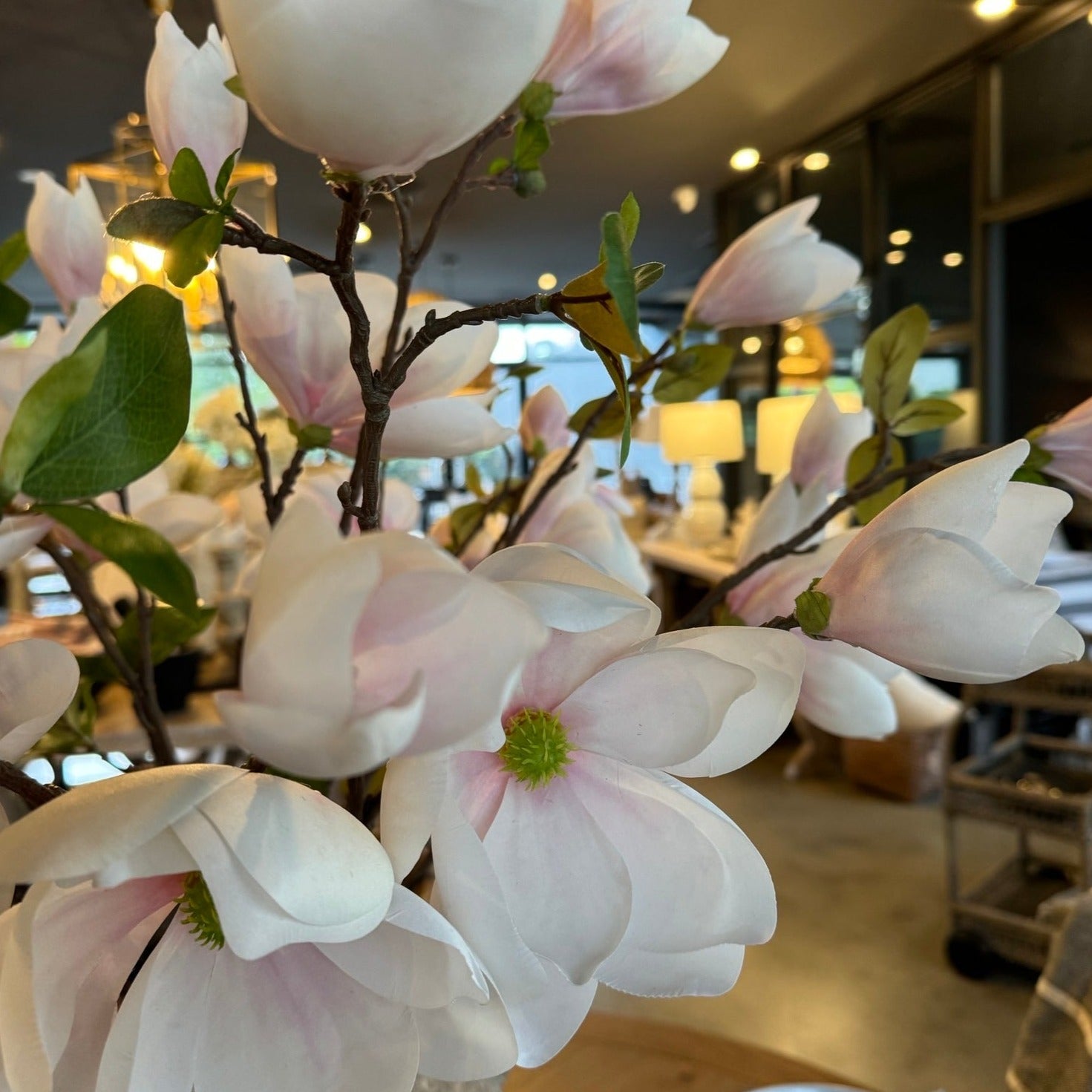 Indulge in the stunning beauty of nature with our exquisite White Faux Magnolia Floral Spray. With life-like cream petals, delicate pink accents, and vibrant green buds, this long stem adds a touch of elegance to any space in your home.