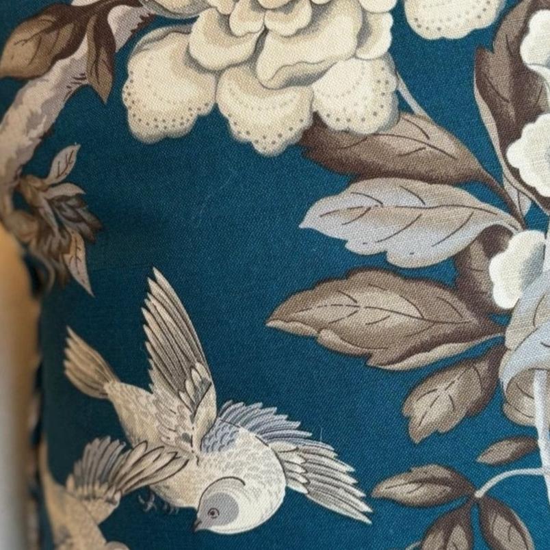 Transform your living space with the breath taking Ophelia Bird &amp; Floral Spray Cushion, adorned with beautiful flying birds and blooming branches on a luxurious teal backdrop. Crafted from soft cotton fabric, this cushion comes with a feather insert for ultimate comfort.