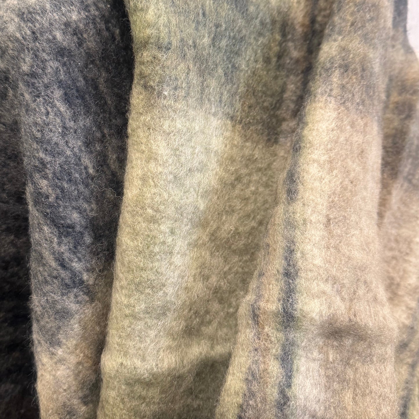 Textured blanket draped over a chair with a blurred indoor setting