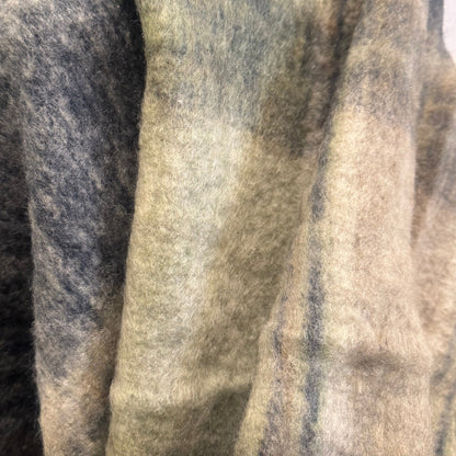 Textured blanket draped over a chair with a blurred indoor setting