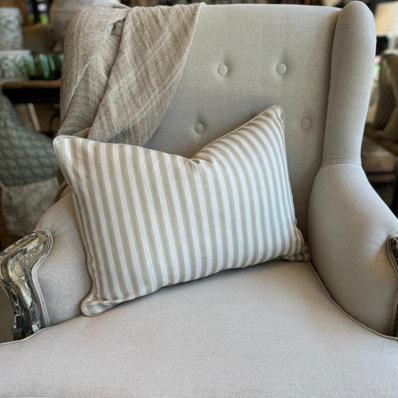 Indulge in the luxurious feel of our Striped Pale Olive &amp; Ivory Lumbar Cushion crafted from a sumptuous heavyweight fabric. The pale olive stripe against ivory background exudes timeless elegance and grace, making it the perfect addition to any sophisticated home decor. Comes with a luxurious feather insert for added comfort.